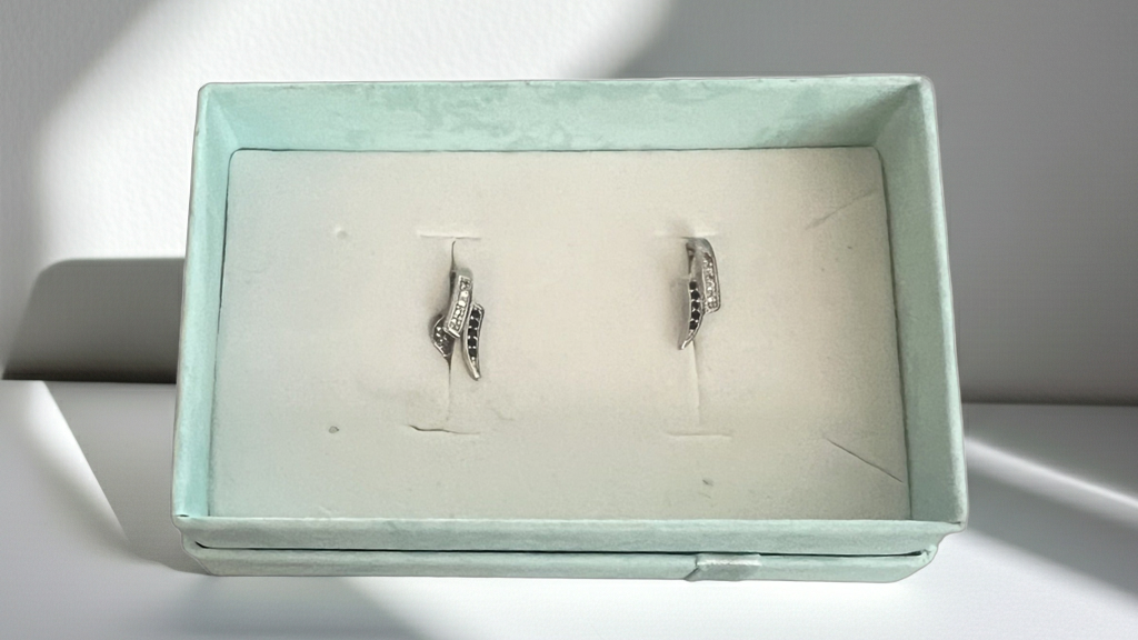 Silver-tone curved wave stud earrings set with alternating clear and black rhinestones, alternate view