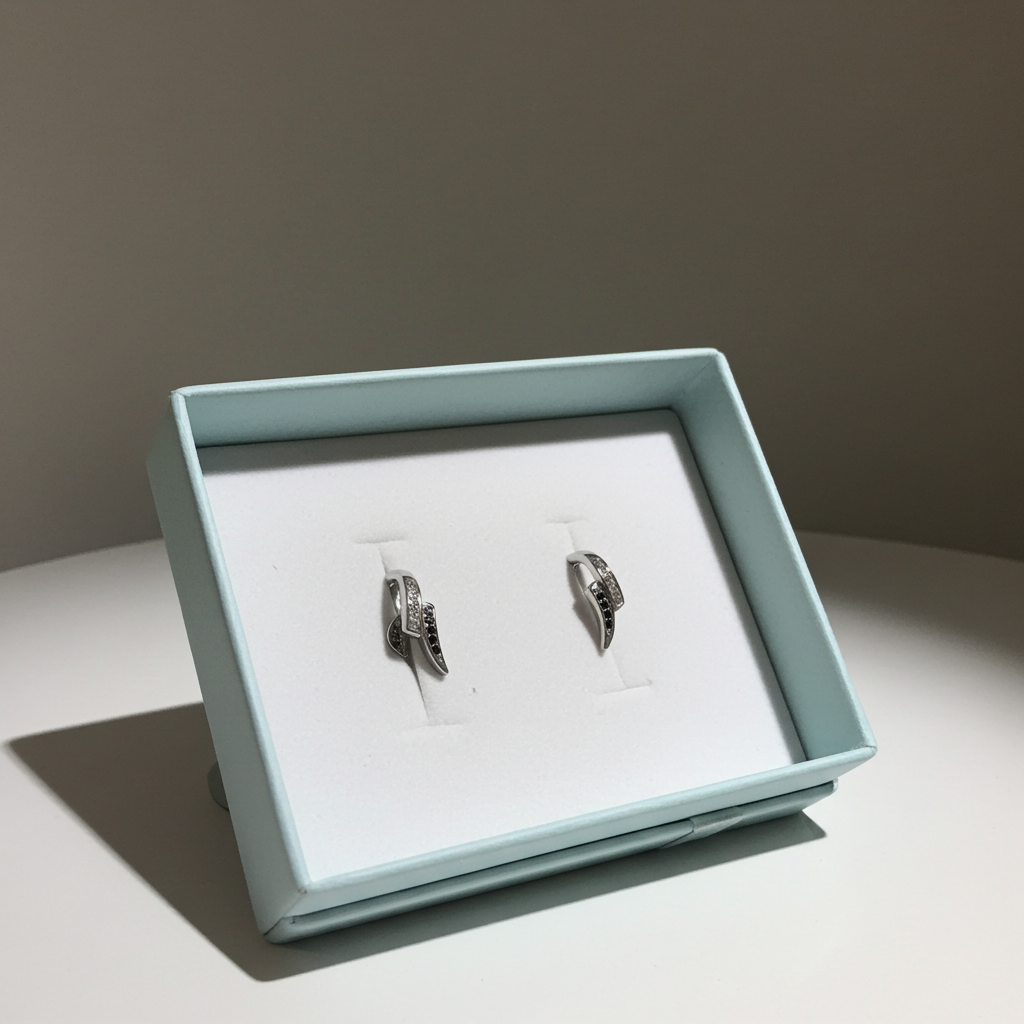 Silver-tone curved wave stud earrings set with alternating clear and black rhinestones, additional view