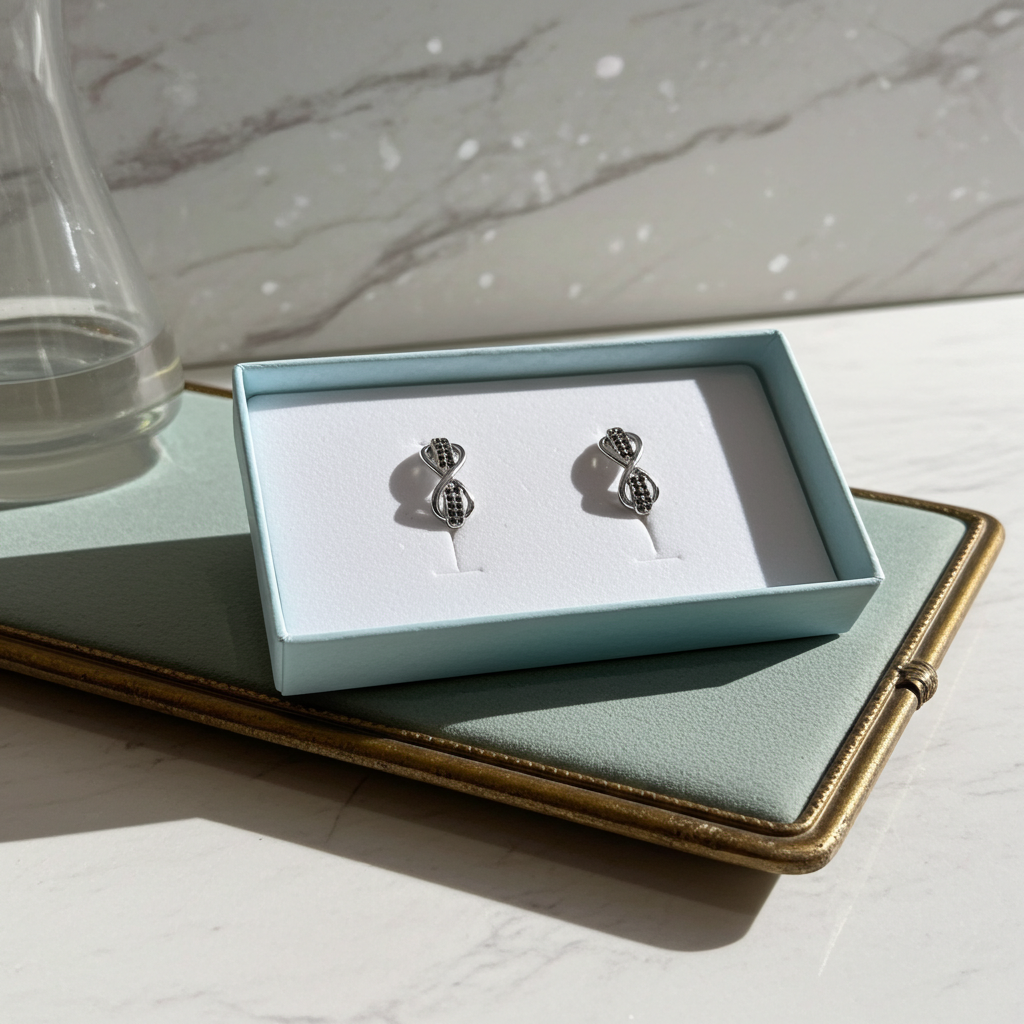 Black and clear rhinestone infinity twist stud earrings in silver-tone, detail view