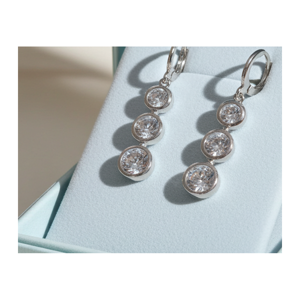 Three-stone bezel rhinestone drop earrings, silver-tone leverback, plain background