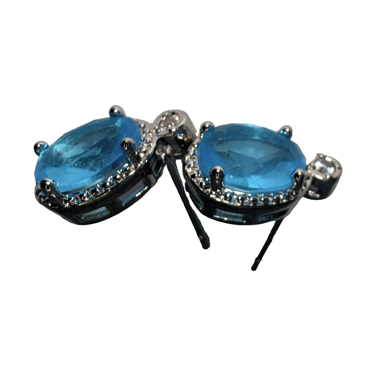 Silver-tone drop earrings with oval blue stones and rhinestone halos, angled view