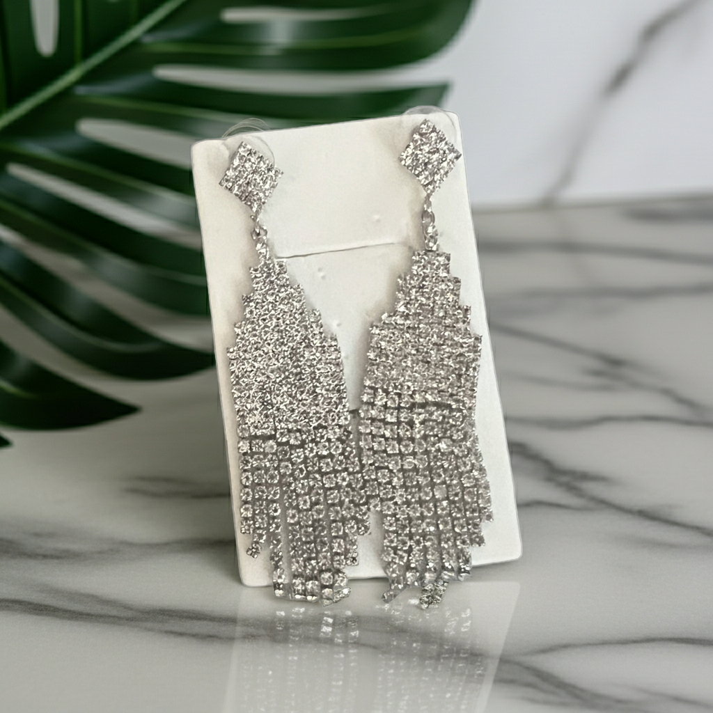 Clear rhinestone chandelier fringe statement earrings in silver-tone with graduated strands, angled view
