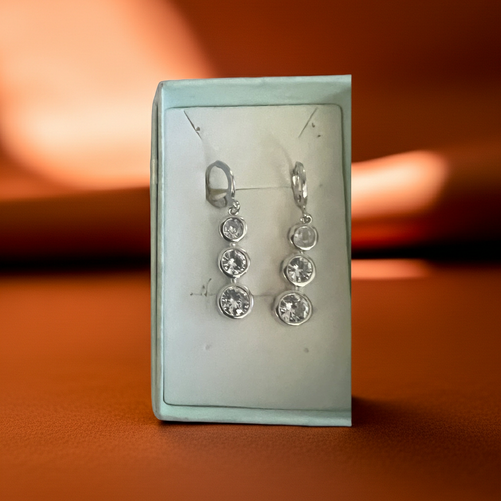 Three-stone bezel-set rhinestone drop earrings in silver-tone with leverback closure, detail view