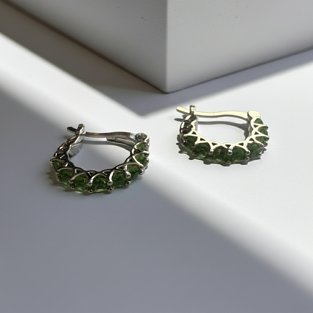 Silver-tone hoop earrings, a row of round green rhinestones in prong settings with an openwork gallery, latch back, additional view